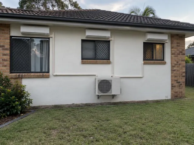 Three wall-mounted split system heads and an outdoor unit on a brick and rendered house in Oxenford